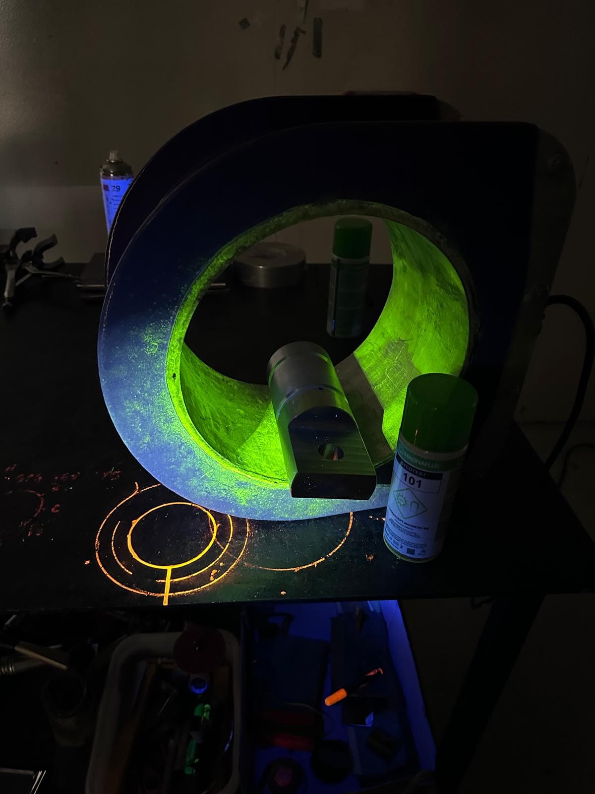 NDT tester examining a metal part using magnetic particle inspection tool