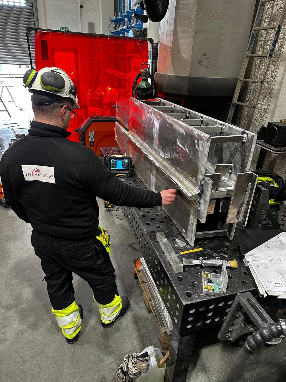 Inpector using ultrasonic inspection tool to inspect a metal assembly